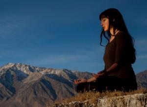 meditating woman byherself in field close up